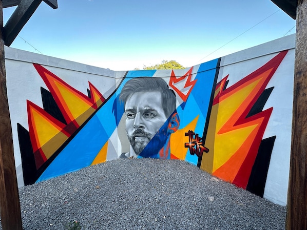 Un túnel con un mural colorido que presenta un rostro y patrones geométricos.