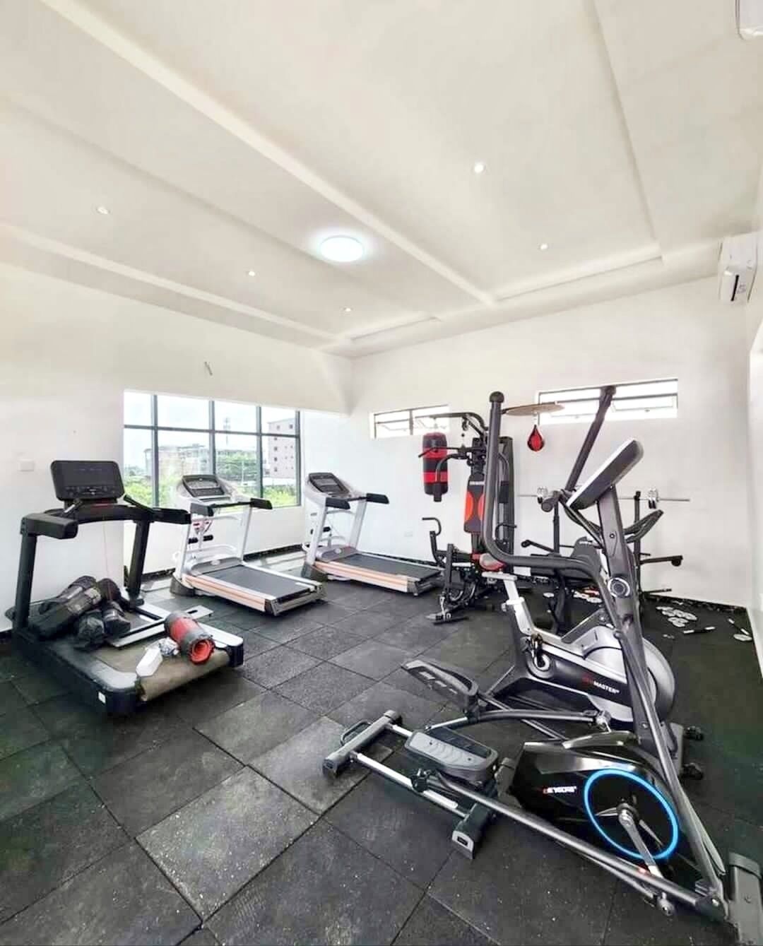 A gym with treadmills, elliptical machines, and weightlifting equipment.