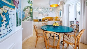 Un coin repas avec une table ronde, des chaises en osier et un saladier rempli de citrons.