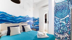 Une chambre à coucher avec un lit, des oreillers, une table de chevet et une fresque murale.