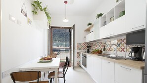 Een moderne keuken met witte kasten, een houten aanrechtblad en uitzicht op een bergachtig landschap.