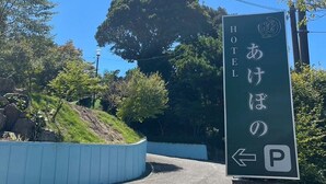 Placa de hotel com caracteres japoneses e símbolo de estacionamento.