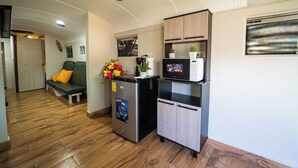 A compact kitchenette with a refrigerator, microwave, and small cabinet.