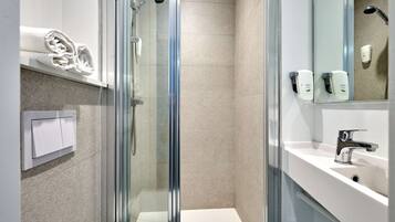 Een douche, handdoeken, shampoo, toiletpapier