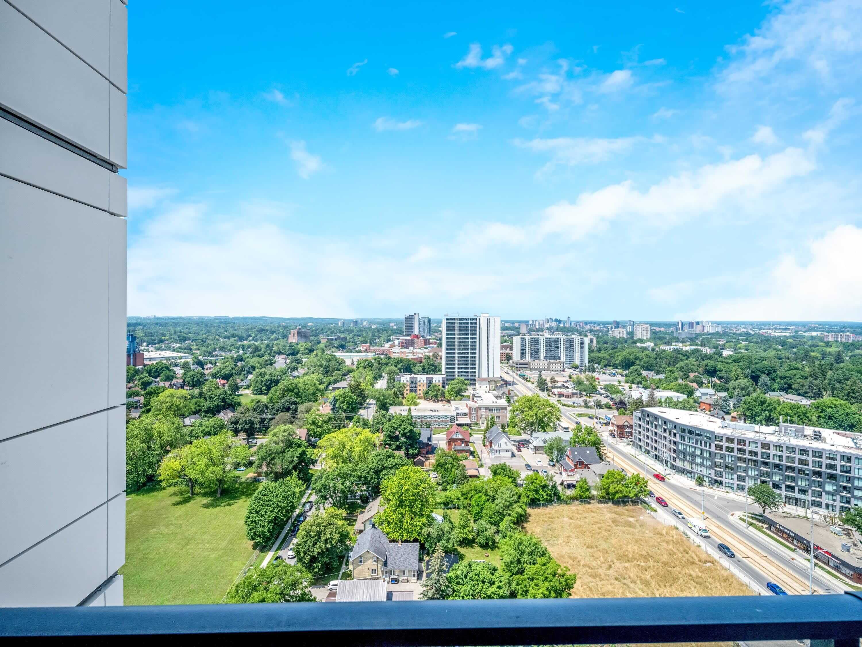 A high-rise building with multiple floors, surrounded by greenery and other buildings.