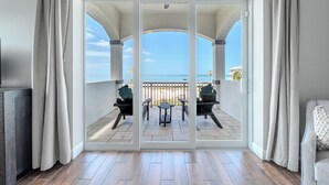 A room with a sliding glass door leading to a balcony with a view of the sea. - Island Grande across the street from beach (Fort Myers Beach)