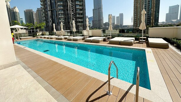 A rooftop pool with lounge chairs and umbrellas, surrounded by high-rise buildings. - Sumptuous 1BR at Act One Act Two Tower 1 Downtown Dubai by Deluxe Holiday Homes (Dubai)