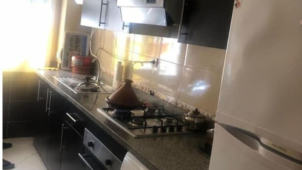 Una cocina compacta con estufa a gas, horno integrado, lavadora y refrigerador.