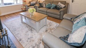 A living room with a sofa, a coffee table, and a lamp. - Owen Tucker View House (Ardara)