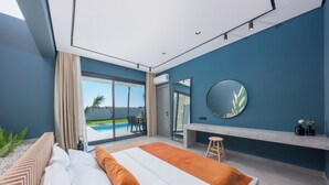 Une chambre moderne avec un grand lit, un bureau et une vue sur une piscine.