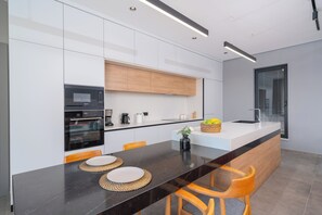 A modern kitchen with a black countertop, wooden cabinets, and a built-in oven.