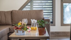 Ein Holztisch mit Blumenarrangements, einem Saftkrug mit Orangensaft und einer Topfpflanze.