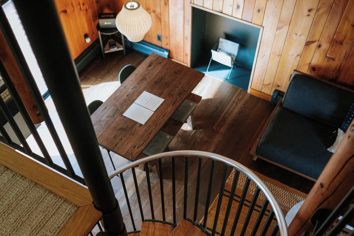 A wooden interior with a spiral staircase, a dining area, and a seating area.