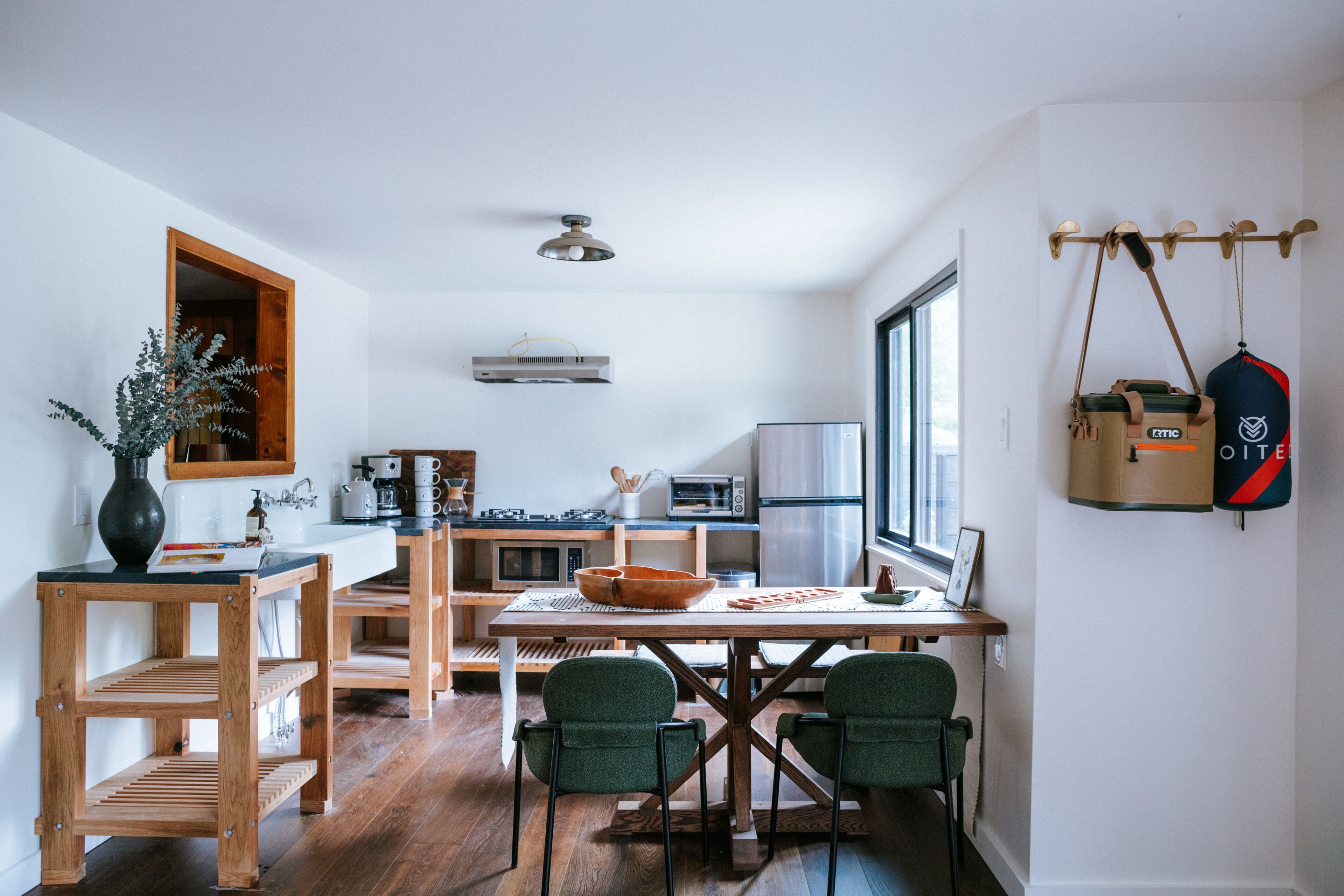 A modern kitchen with wooden furniture, a dining table, and chairs.