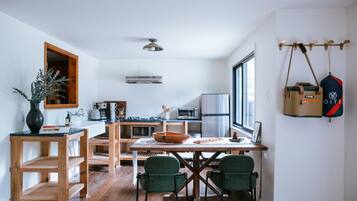 A modern kitchen with wooden furniture, a dining table, and chairs.
