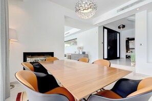 Enjoy meals in this stylish dining area with a large table and comfortable seating for six, a fireplace, and a TV.