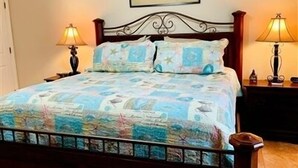 A bed with a blue and white patterned bedspread, two bedside lamps, and a framed picture on the wall above the bed. - Wake Up to a Beautiful View! 3bdrm, 2 bath. Private Fishing Pier. (Port Mansfield)