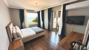 Una habitación de hotel moderna con una cama, un escritorio, un hervidor de agua y un televisor.