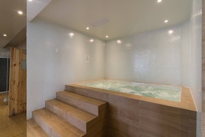A spa room with a wooden staircase leading to a hot tub area. - Rare Gem! Indoor Pool, Rooftop, Center of the City (Quito)
