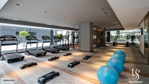 Een moderne sportschool met loopbanden, stepplatforms en fitnessballen.