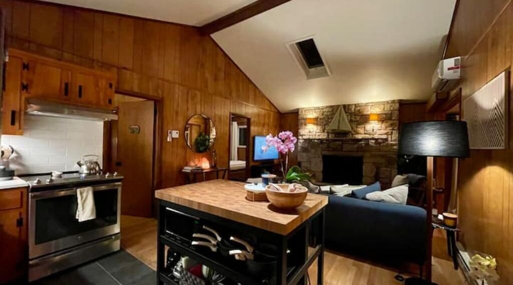 Una cocina acogedora con armarios de madera, una isla central y una chimenea de piedra.