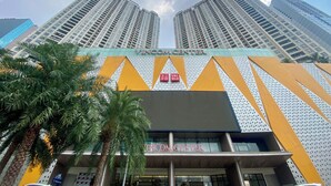 A modern building with a prominent 'VINCOM CENTER' sign, surrounded by high-rise buildings and palm trees. - Vinhome D'capitale Service Apartment - Mikage Housing (Hanoi)