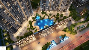 A high-rise residential building with a central courtyard featuring a swimming pool, surrounded by greenery and pathways. - Vinhome D'capitale Service Apartment - Mikage Housing (Hanoi)