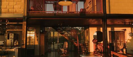 A spacious interior with a high ceiling, a staircase, and a dining area.