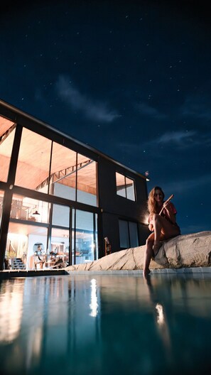 A modern building with large windows and a swimming pool. - CASA ÔNIX (Alto Paraíso de Goiás)