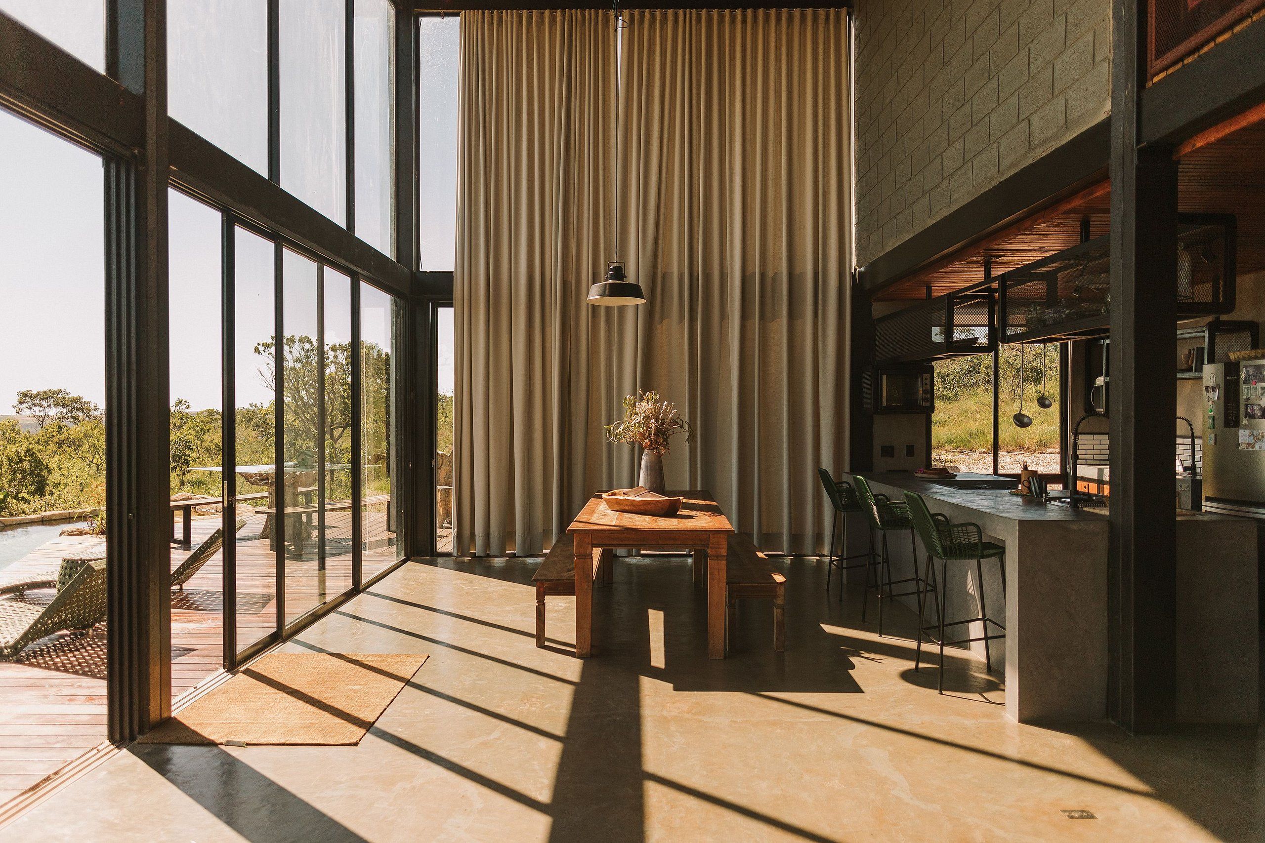 Una cocina moderna con barra, ventanas amplias y vistas al exterior.