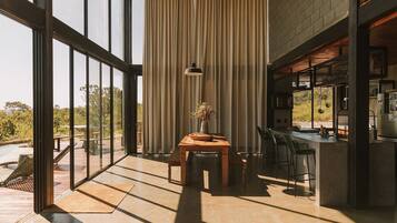 Una cocina moderna con barra, ventanas amplias y vistas al exterior.
