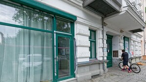 Un bâtiment doté de grandes fenêtres, et une personne qui passe.