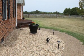 A brick building with a gravel pathway leading to a wooden fence. - "FARM CHARM" w/Mtn Views~Fire Pit~Family Friendly (Luray)