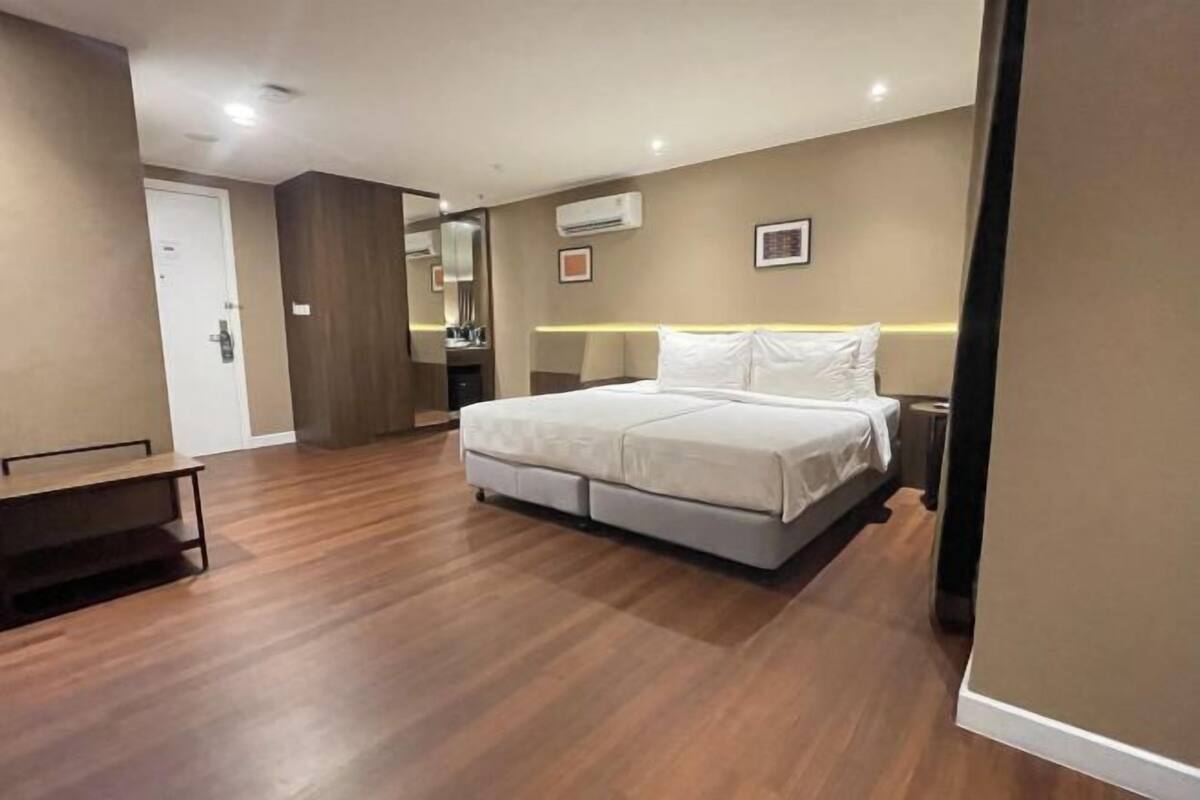 Un dormitorio con cama, mesita de noche y espejo.