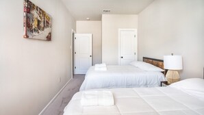 A hotel room with two beds, a painting on the wall, and a lamp on the nightstand. - Bayou Bengal Royal Stay-n-Tailgate by LSU - BC1025 (Baton Rouge)