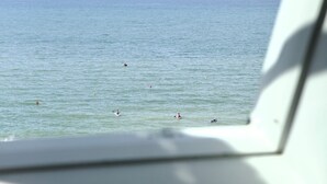 Vista desde una ventana de un mar tranquilo con varios barcos y boyas.