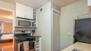 A compact kitchen with a stove, oven, microwave, and refrigerator. - Studio, perfect for students on rotation at Oregon Health & Sciences University. (Portland)
