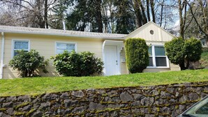 A house with a stone wall, a garage, and a car parked in front. - Studio, perfect for students on rotation at Oregon Health & Sciences University. (Portland)