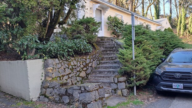 A row of parked cars along a residential street with a stone staircase leading to a house. - Studio, perfect for students on rotation at Oregon Health & Sciences University. (Portland)