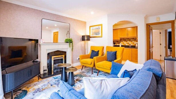 Una sala de estar moderna con chimenea, televisor y sofá.