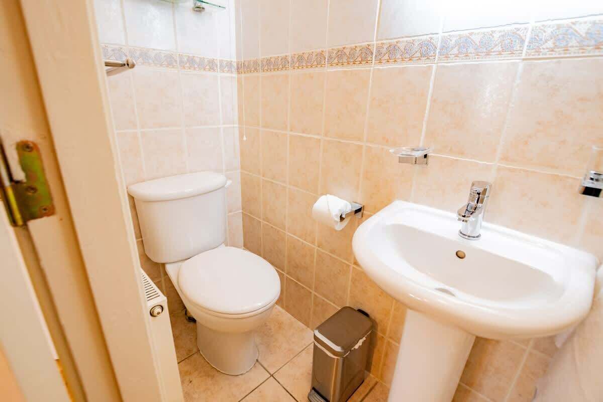 Une petite salle de bain avec des toilettes, un lavabo et une poubelle.