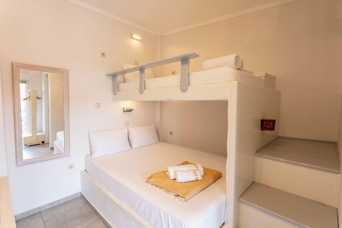 A bunk bed room with a mirror, a towel, and a small shelf.