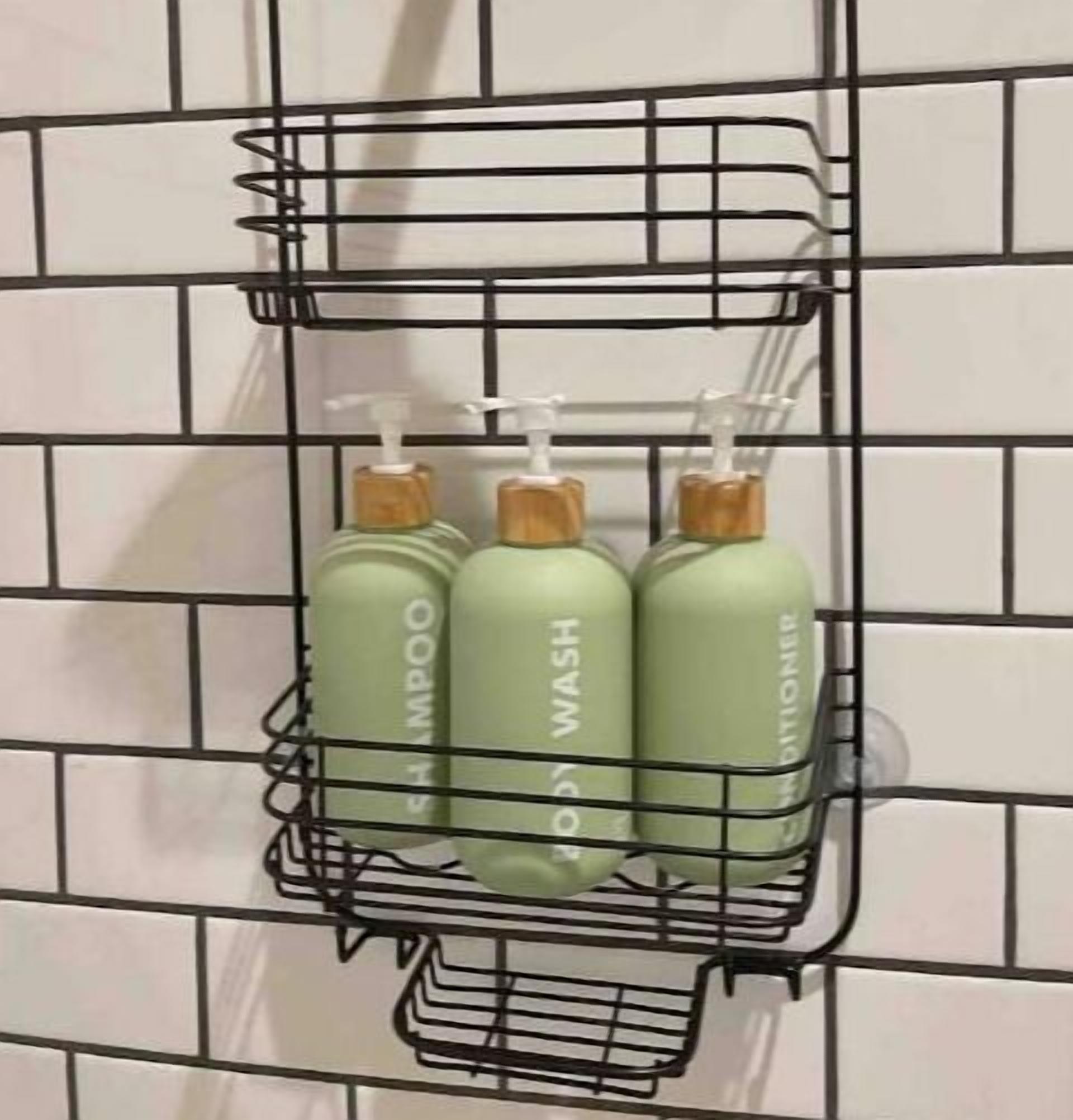 A metal shelf with three bottles of shampoo and conditioner against a tiled wall.