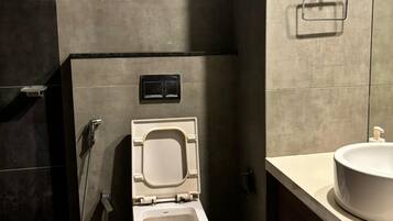Un baño moderno con inodoro, lavabo y ducha.