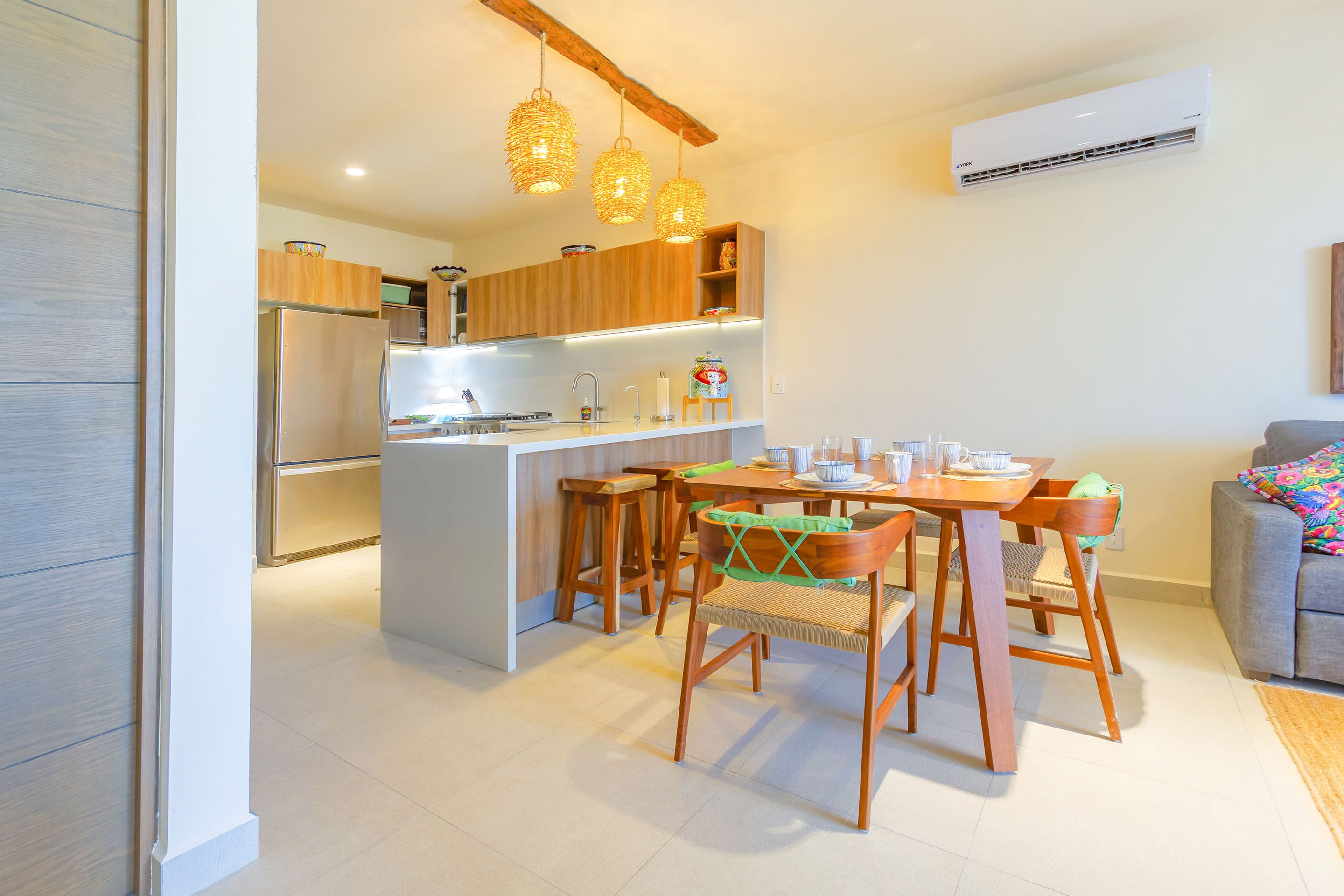 Een moderne keuken met houten kastjes, een centraal eiland en hangende吊り下げランプ.