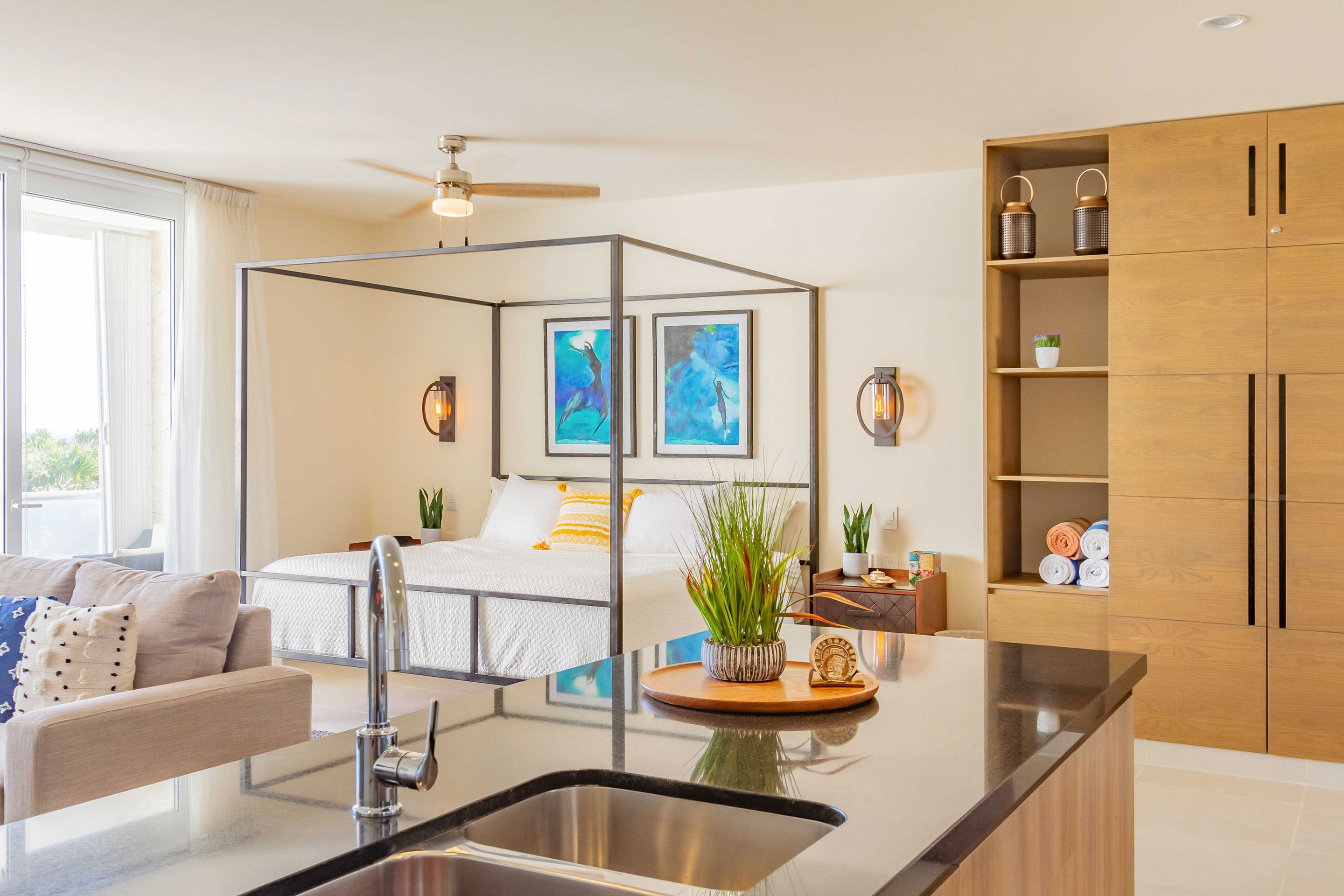Una cocina moderna con una isla central, armarios de madera y un ventilador de techo.