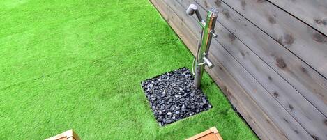 Een stuk kunstgras met een houten omheining en een metalen constructie.