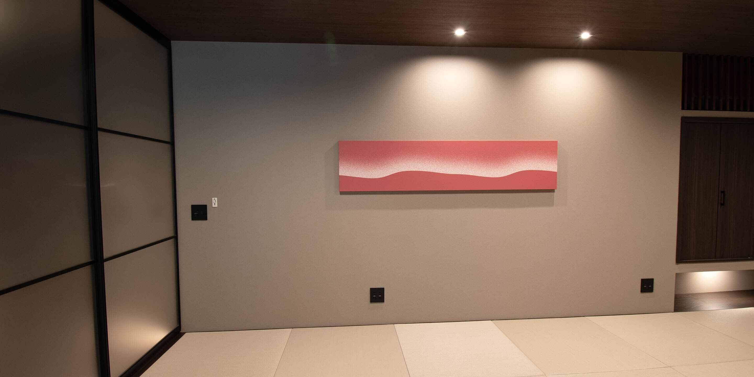 Un intérieur moderne au design minimaliste, agrémenté d’un grand tableau abstrait au mur, d’un éclairage encastré et d’un espace épuré et dégagé.