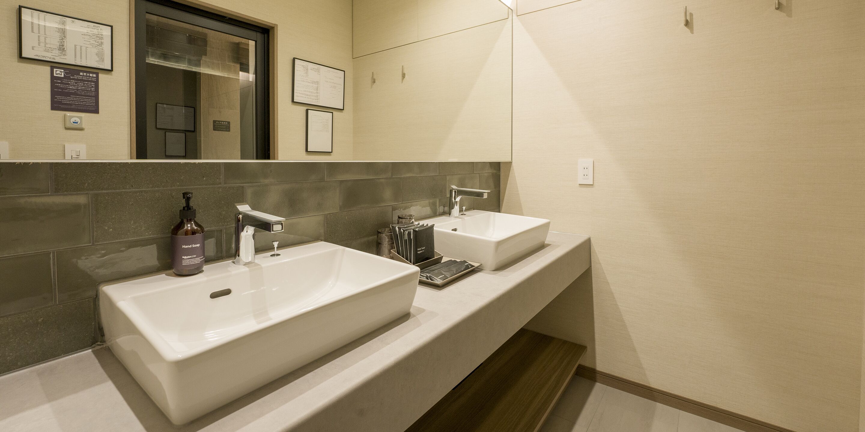 A modern bathroom with two sinks, a mirror, and a towel rack.
