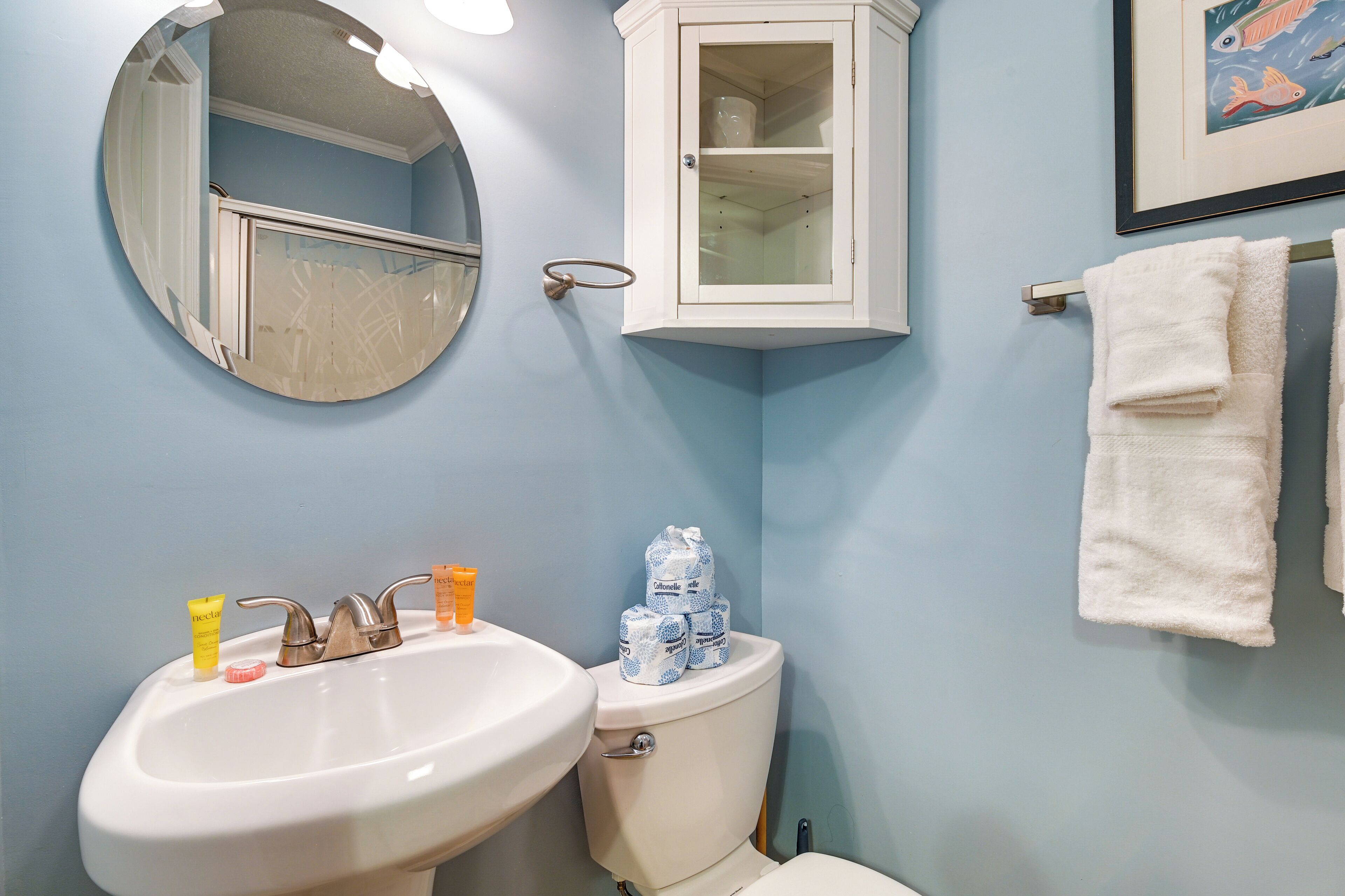 Un baño con lavabo, inodoro y mueble de almacenamiento.